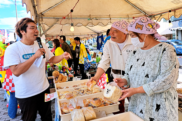 おおね秋祭りの総合司会をつとめた「昨日のカレーを温めて」みんなのおさむさんからインタビューをうける齋木ご夫妻